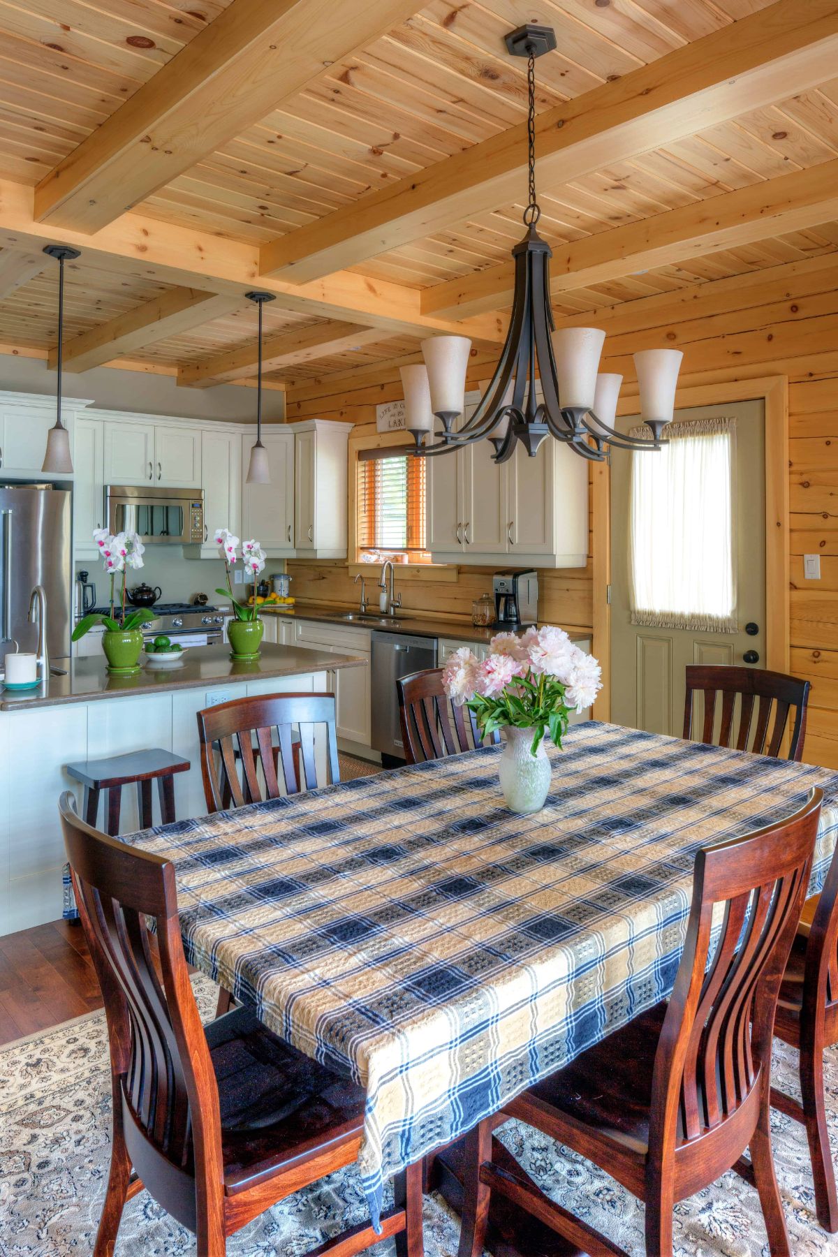 plaid tablecloth on table by kitchen with dark wood chairs