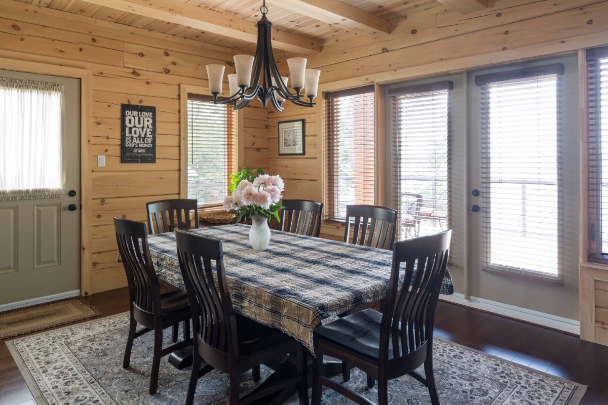 dark wood chairs around table by french doors on back of wall