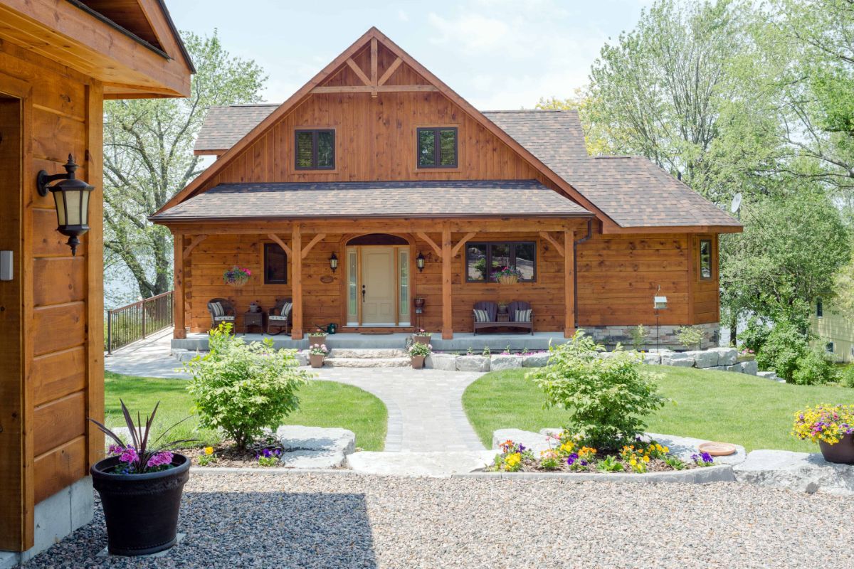 front of log cabin with garage to left of image