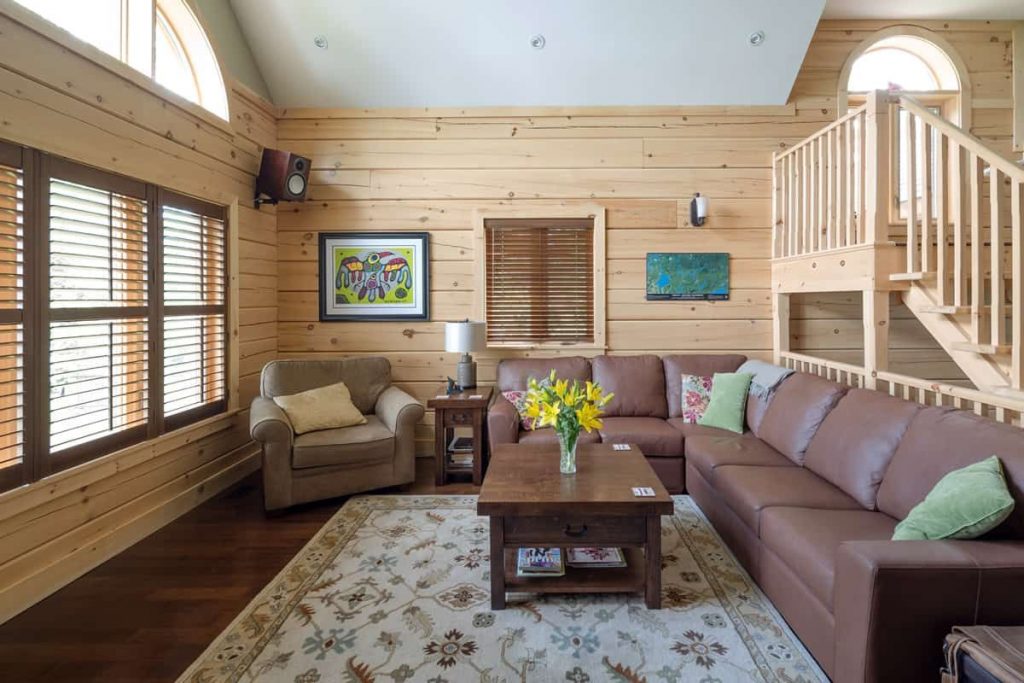 brown leather sofa with wood coffee table in front of open windows