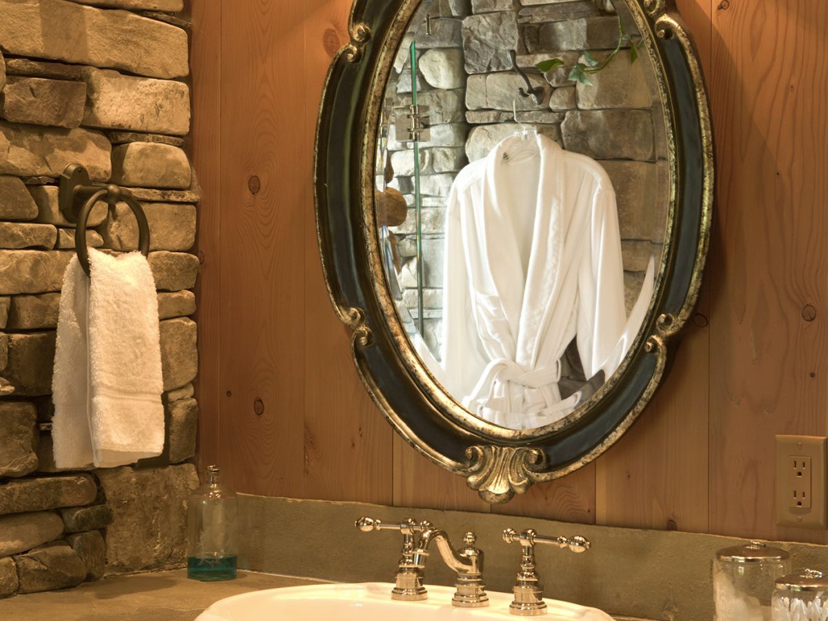 oval ornate mirror above white sink in bathroom