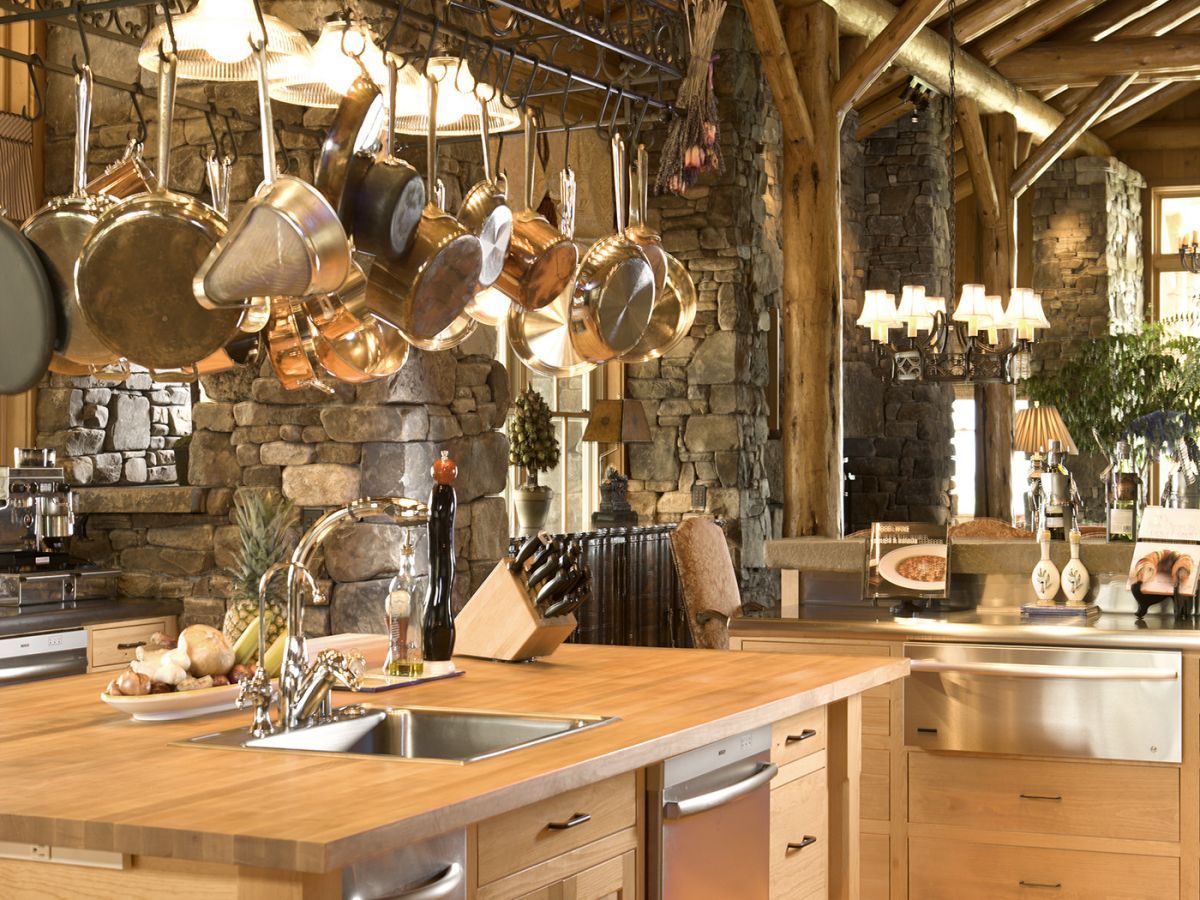 kitchen counter with stainless steel sink and rack of copper pots hanging above countertop