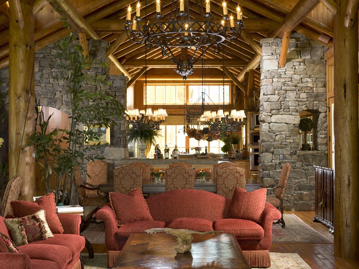 burnt orange sofas in great room with stone columns and log beams