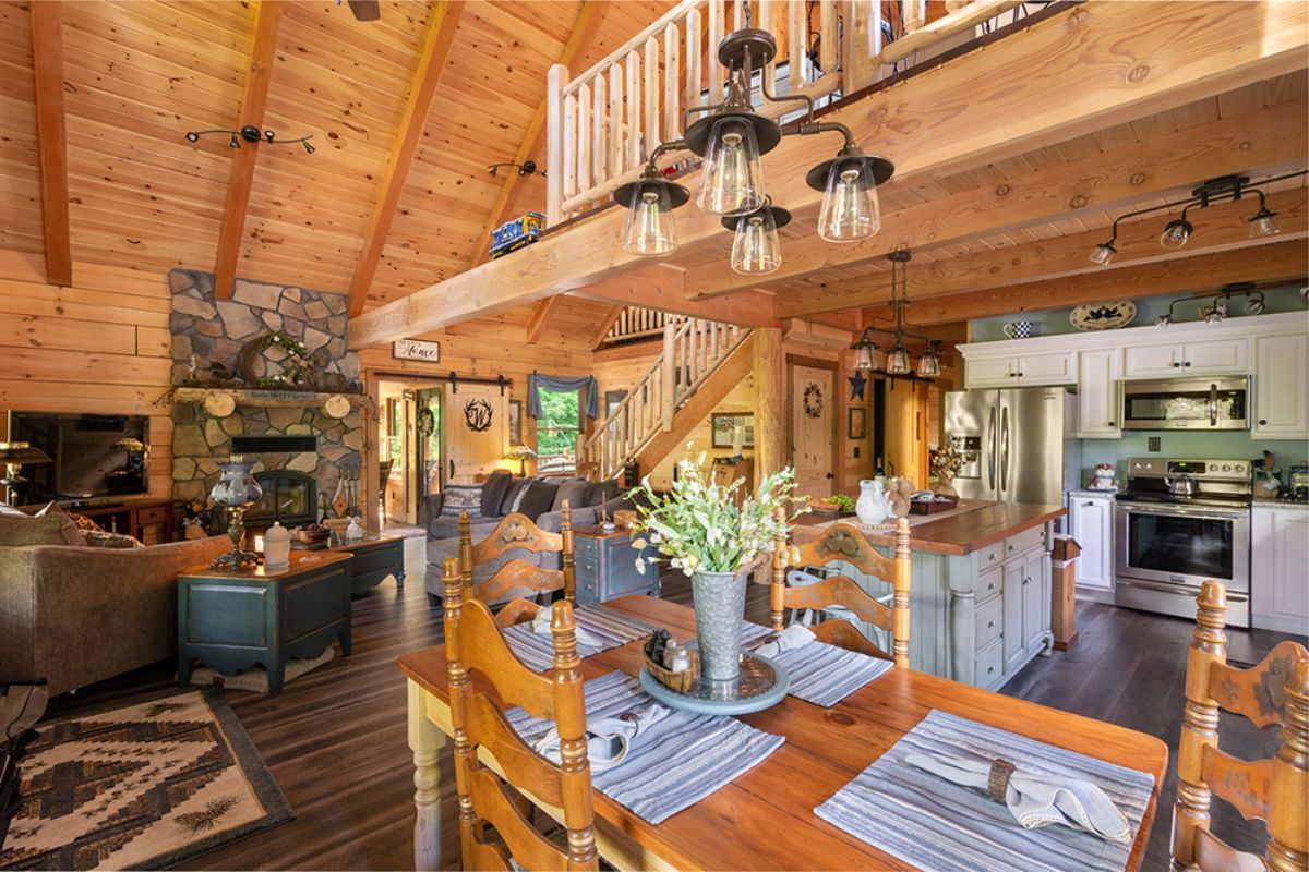 butcher block top on dining table with chandelier above and living room on left and kitchen on right