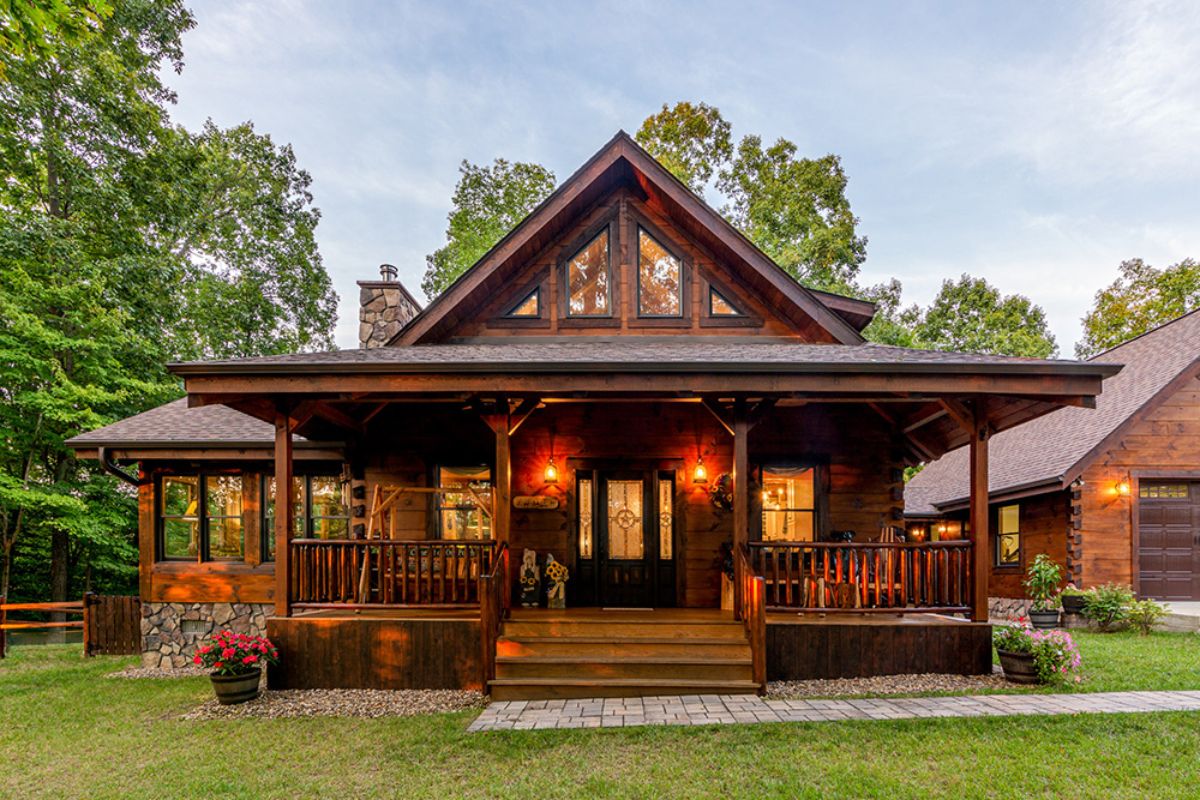 front of dark wood log cabin with covered front porch