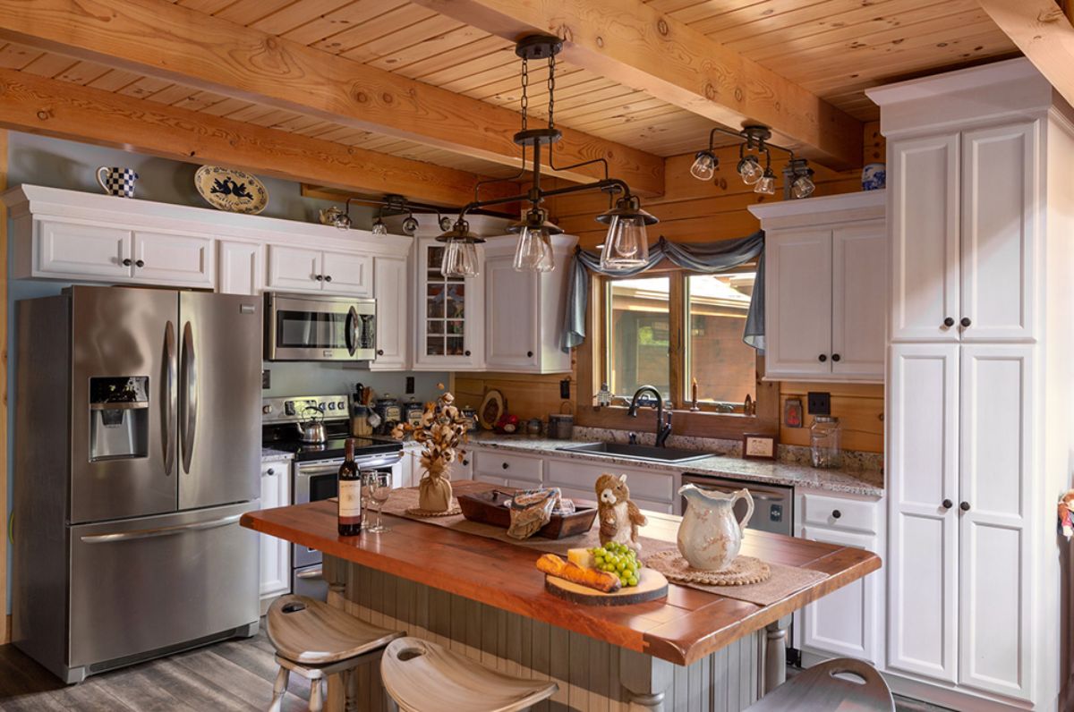 modern kitchen with light cabinets and light green island with butcherblock counter tops