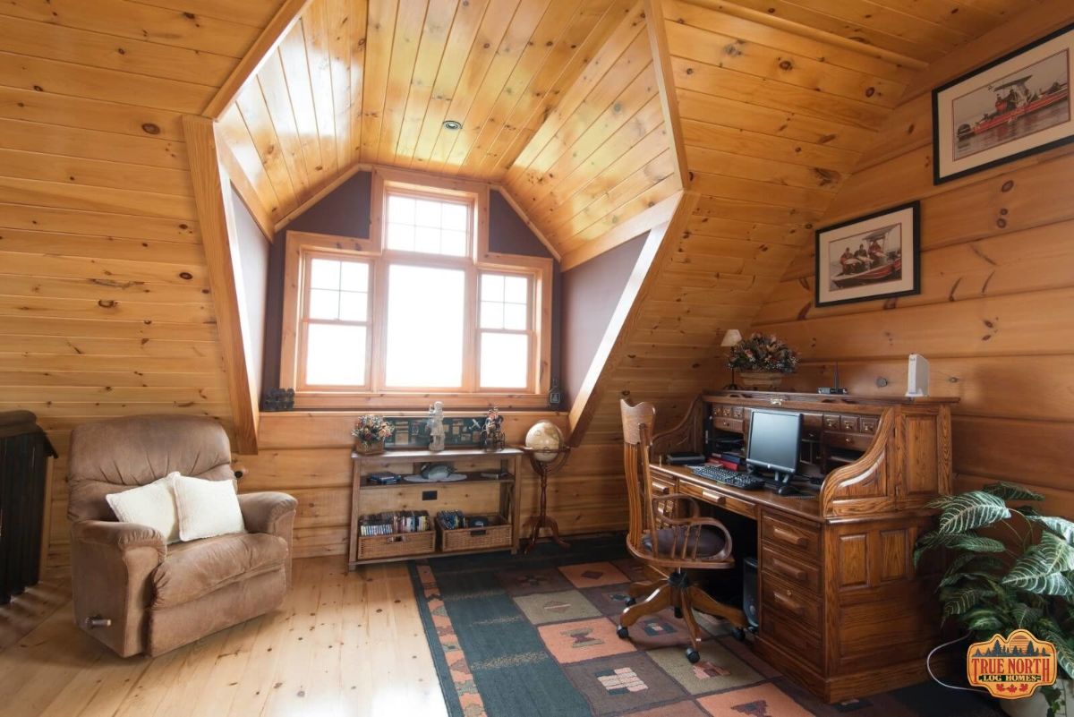 second floor office with desk under eave and table and chair by dormer window