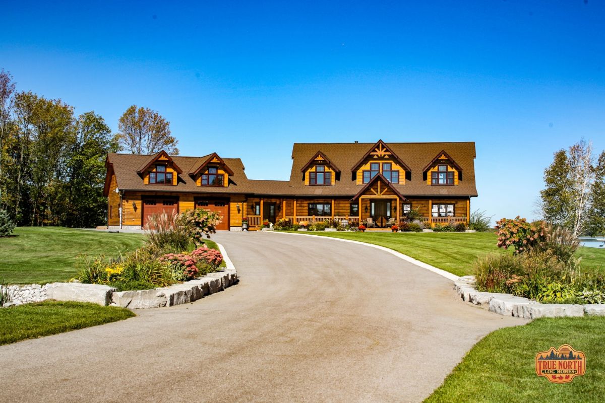 log cabin at back of long driveway with attached garage