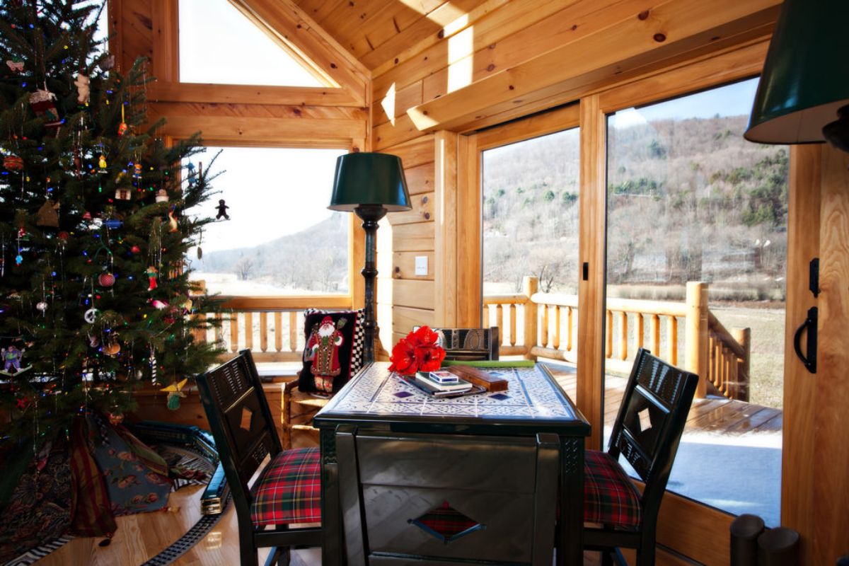 dark wood dining table with red plaid cushions on chairs