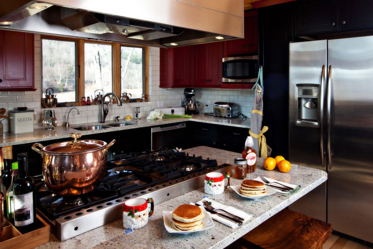 kitchen island with black stove holding copper pot in kitchen