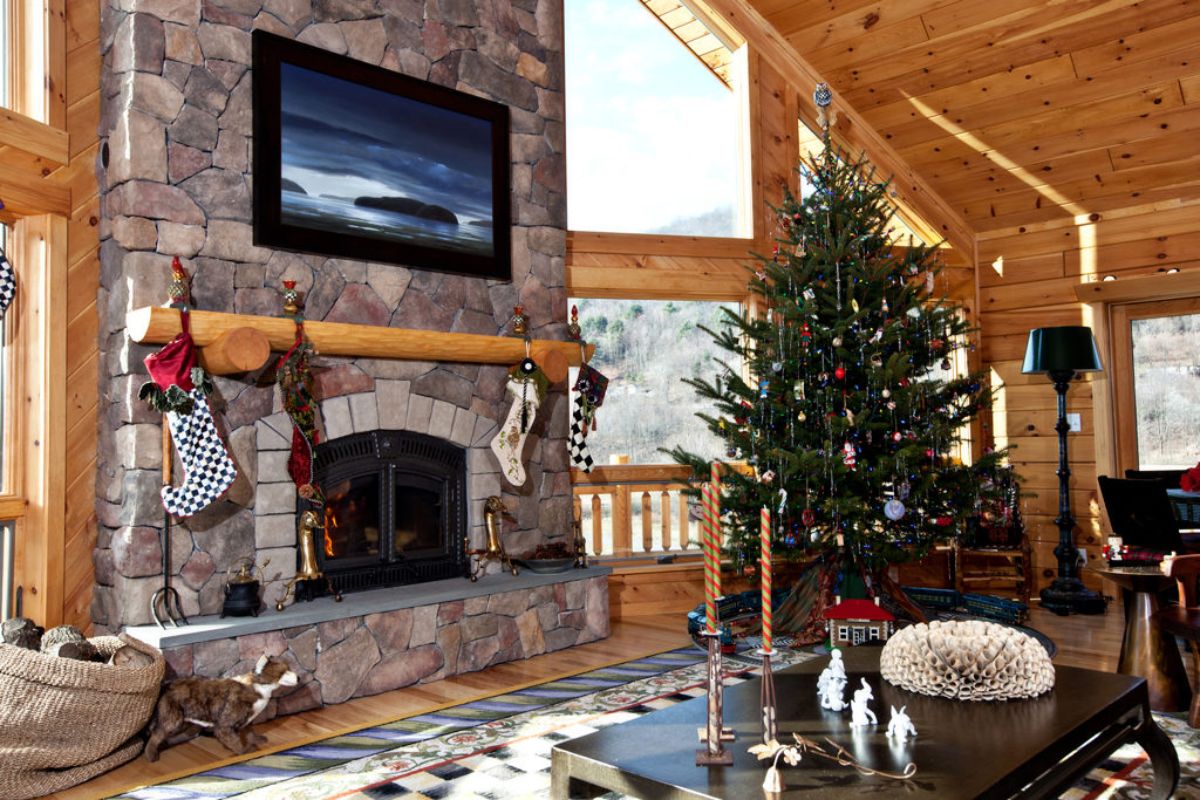 Christmas tree in far right with stone fireplace in front corner