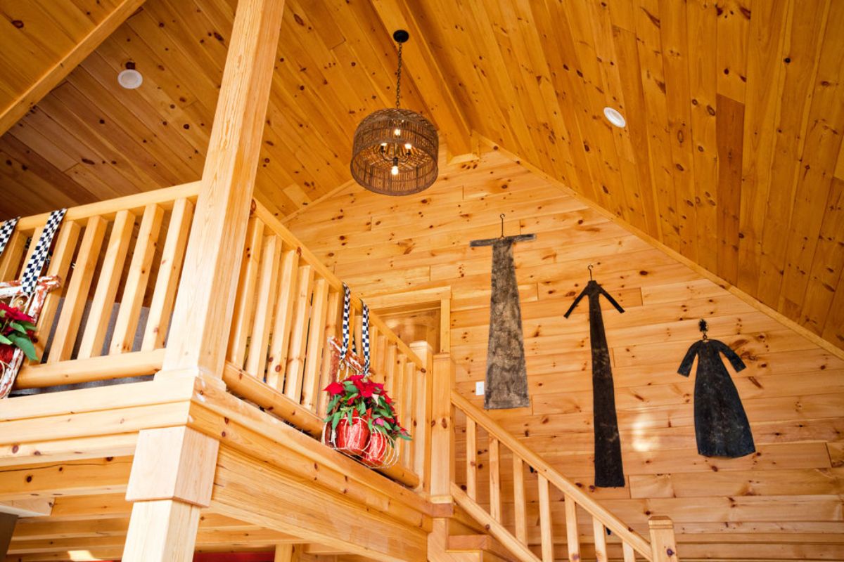 light wood stairs to loft with wall hangings in arch of ceiling