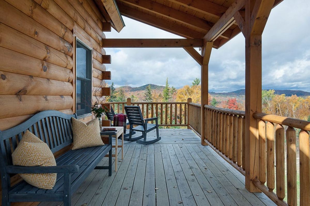 porch with black bench and rocking chair and moutain view in distance