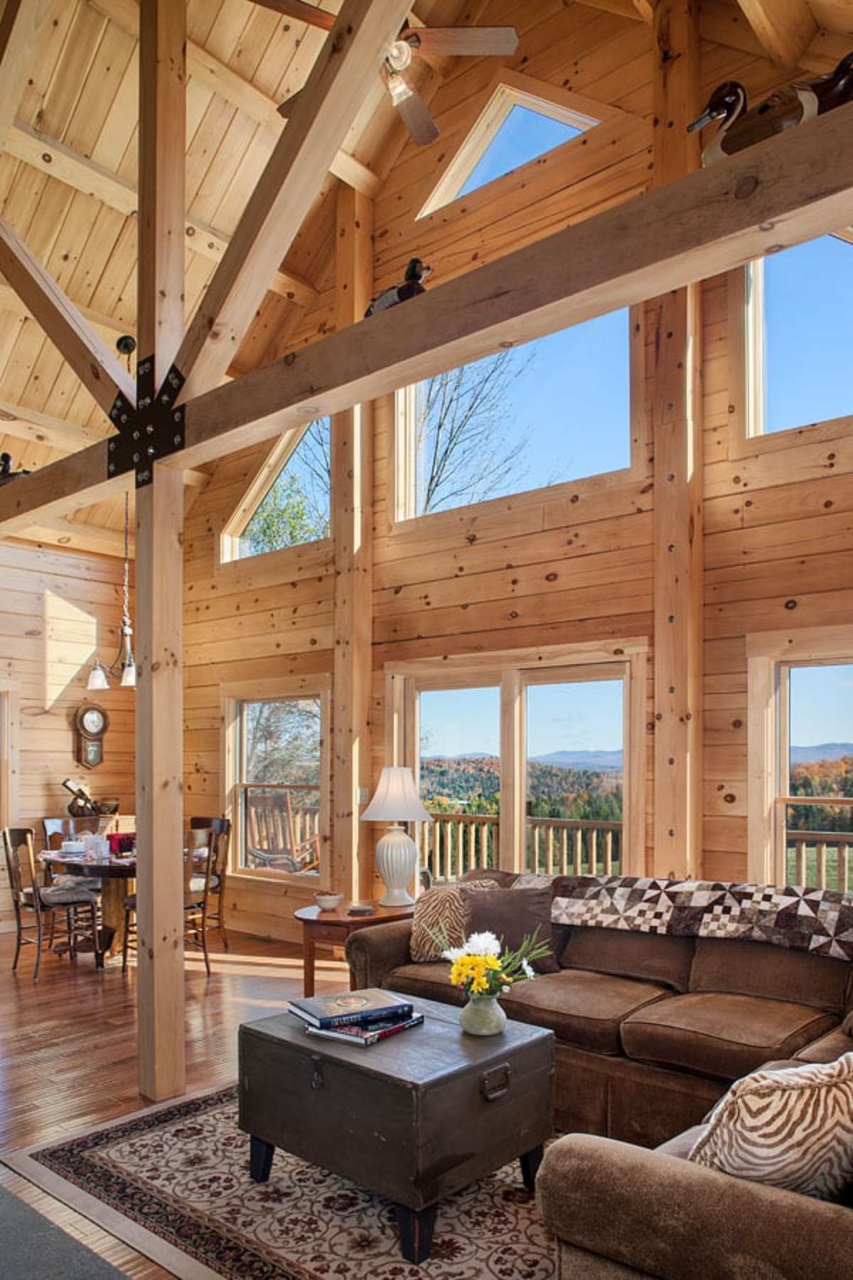 brown sofa against wall of windows on great room in log cabin