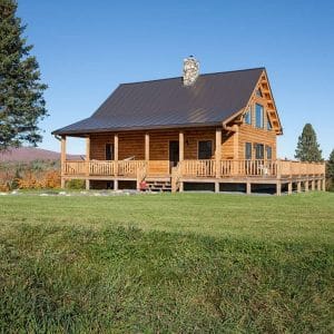 log cabin with brown shingle roof in green field