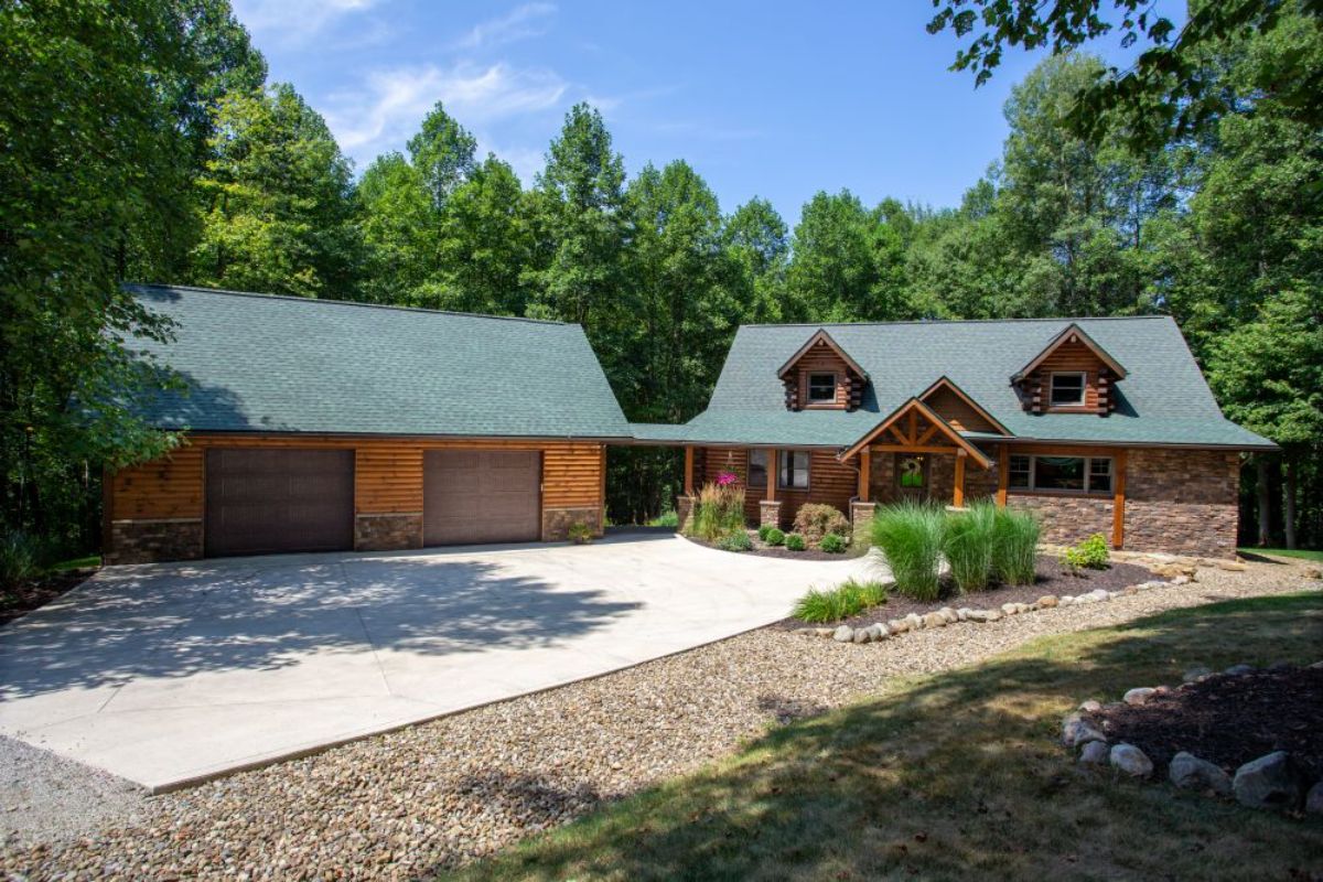 log cabin with concrete drive and attached garage