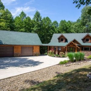 log cabin with concrete drive and attached garage