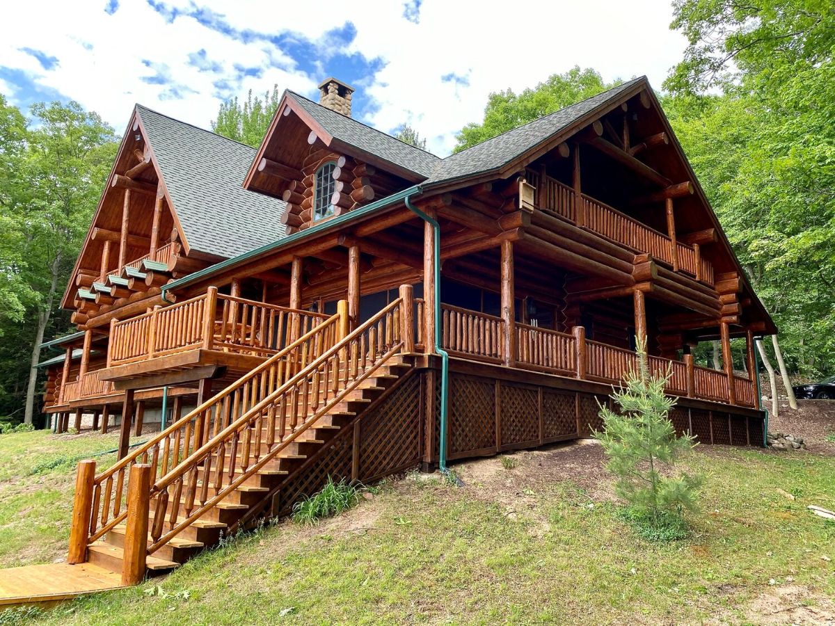 side of log cabin with stairs leading down to lake