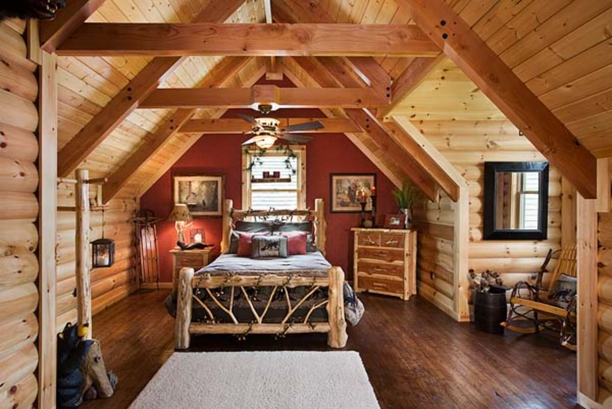 log bedframe in second floor bedroom with red wall and log surround