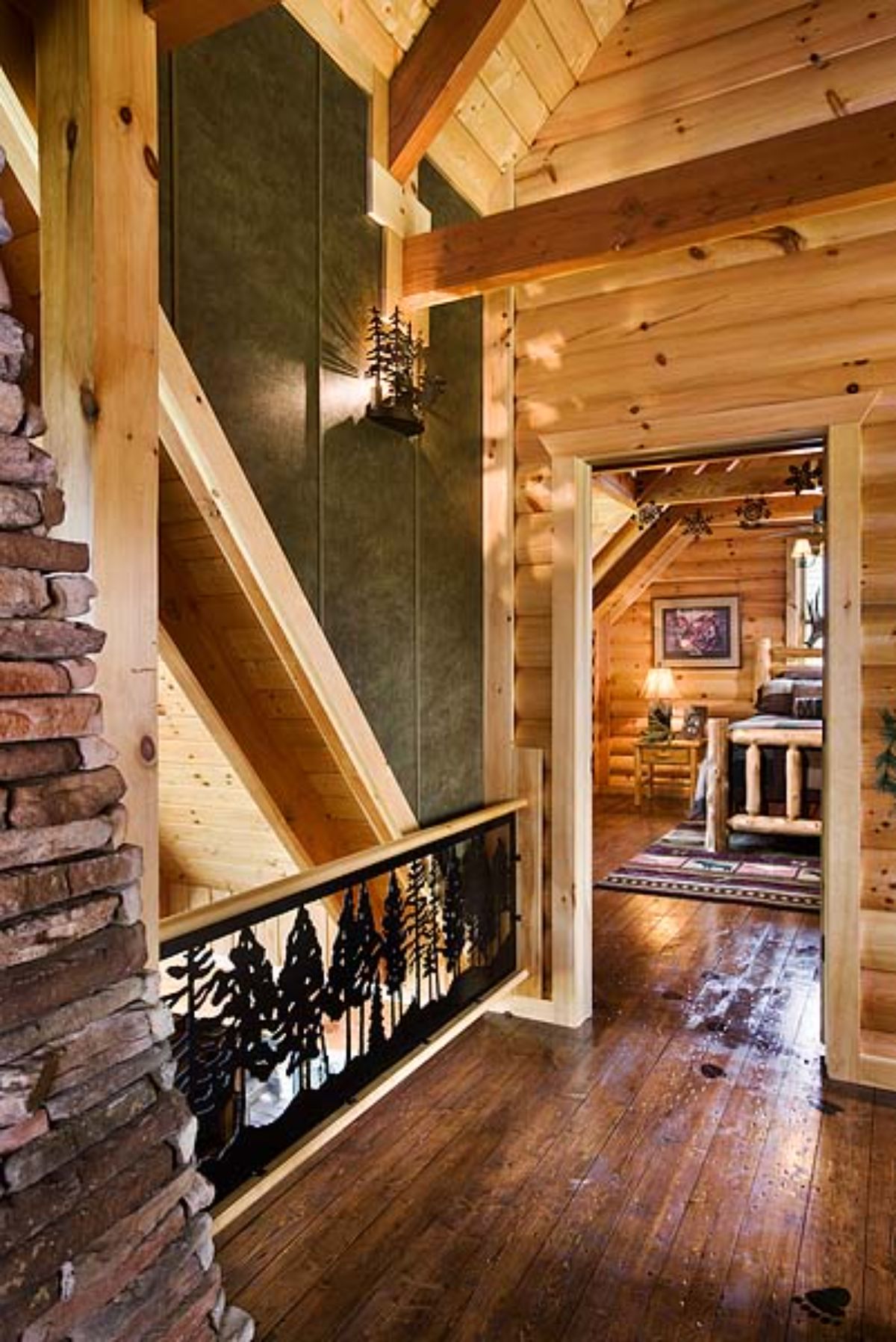 ornate wrought iron railing on loft landing with green wall and open door into bedroom on right