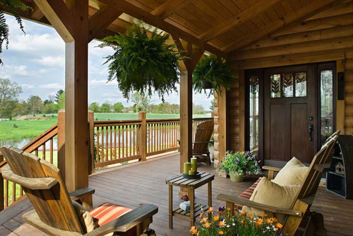 front porch of log home with rocking chair and hanging basket fern