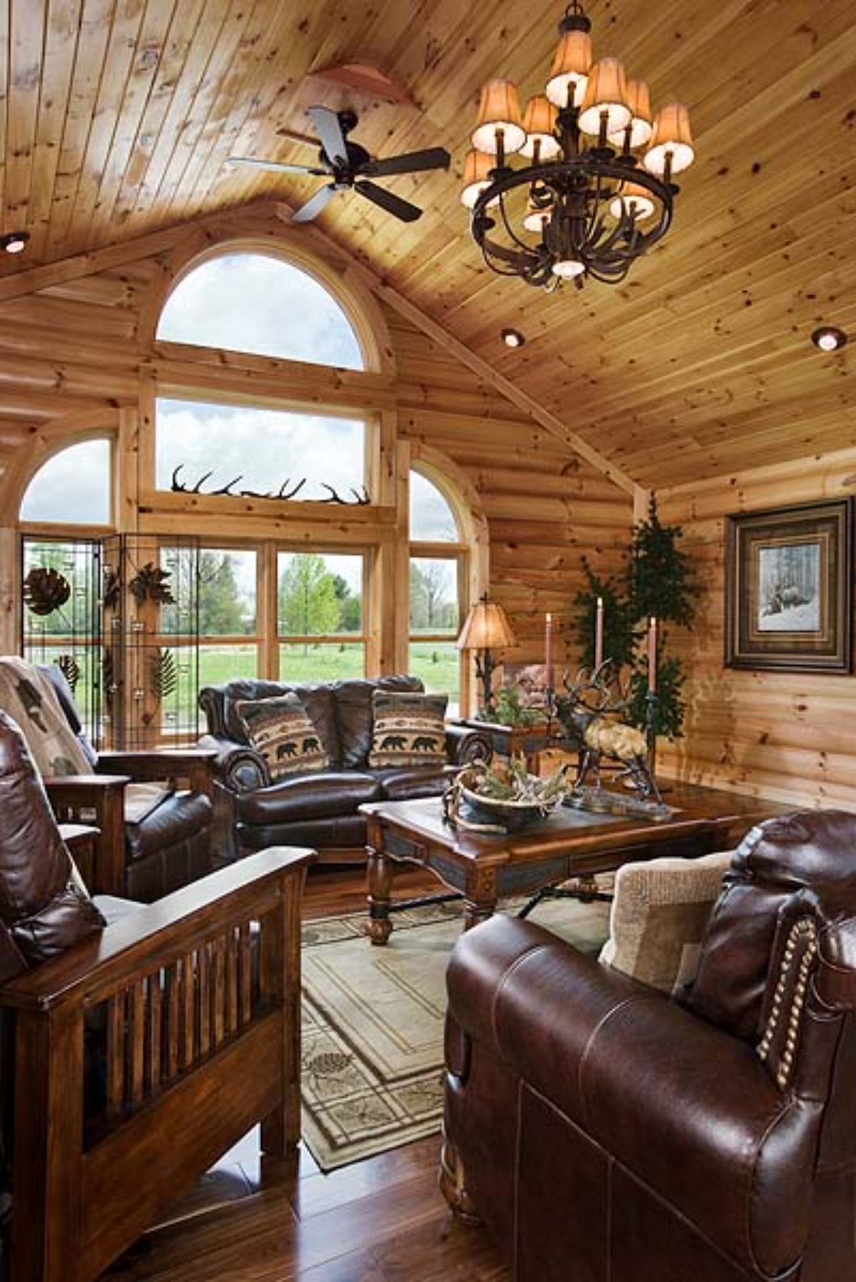 great room with windows on far end and brown leather sofas in foreground