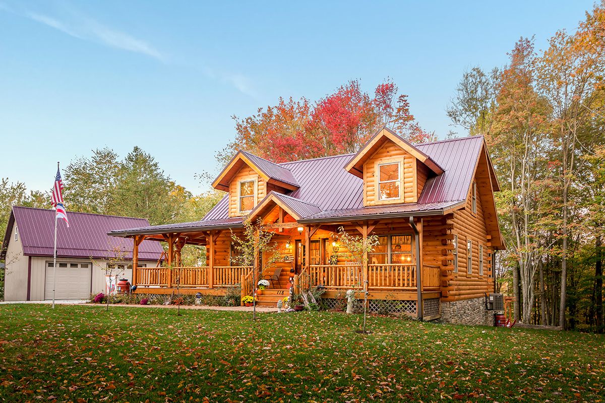 log cabin front with covered porch and two dormer windows