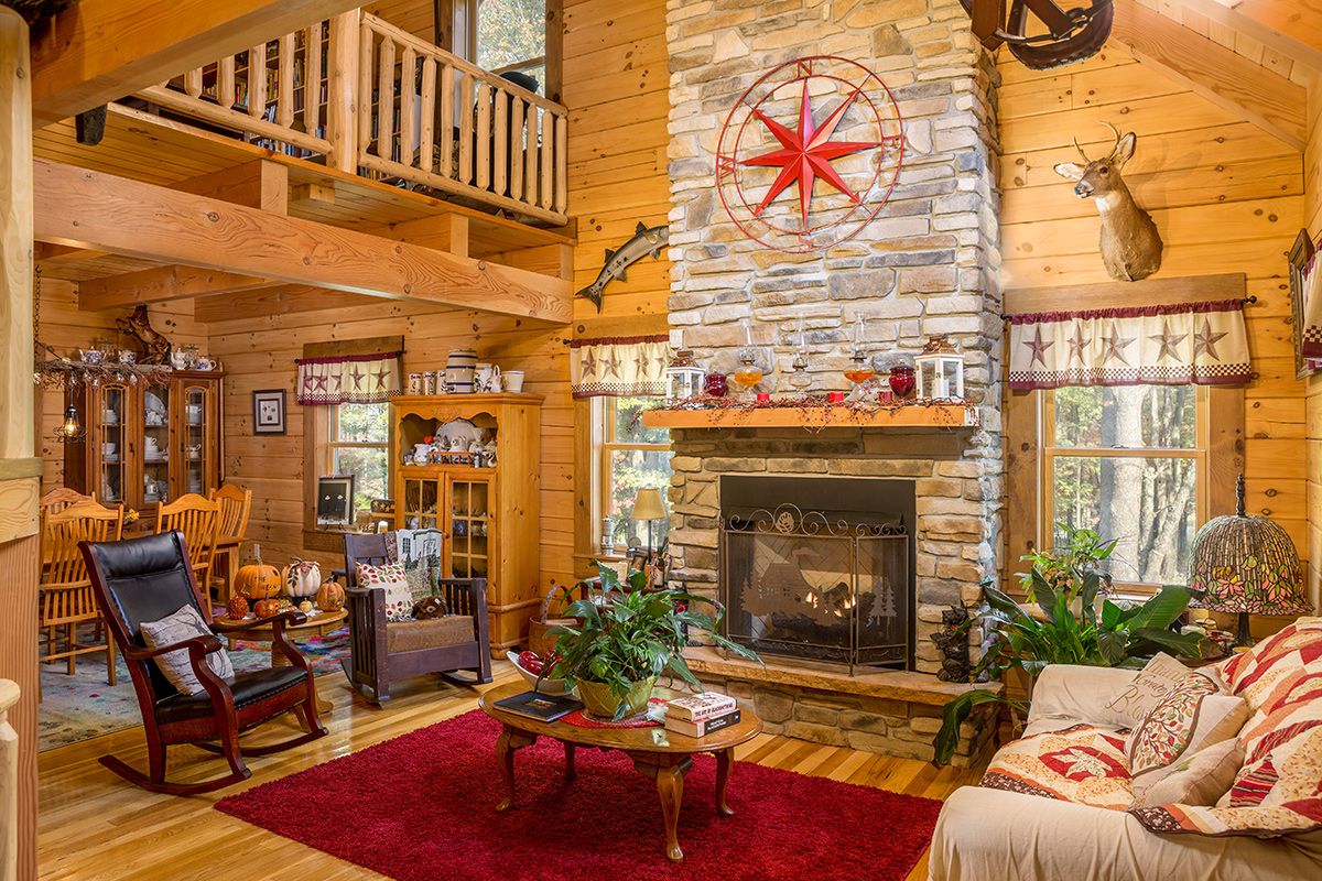 stone fireplace with log mantle and red carpet in front of fireplace