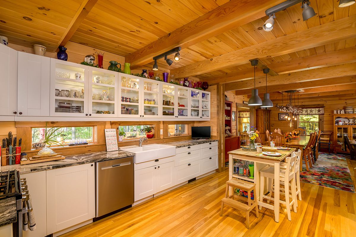 stainelss steel dishwasher in middle of white cabinets against left of image for kitchen