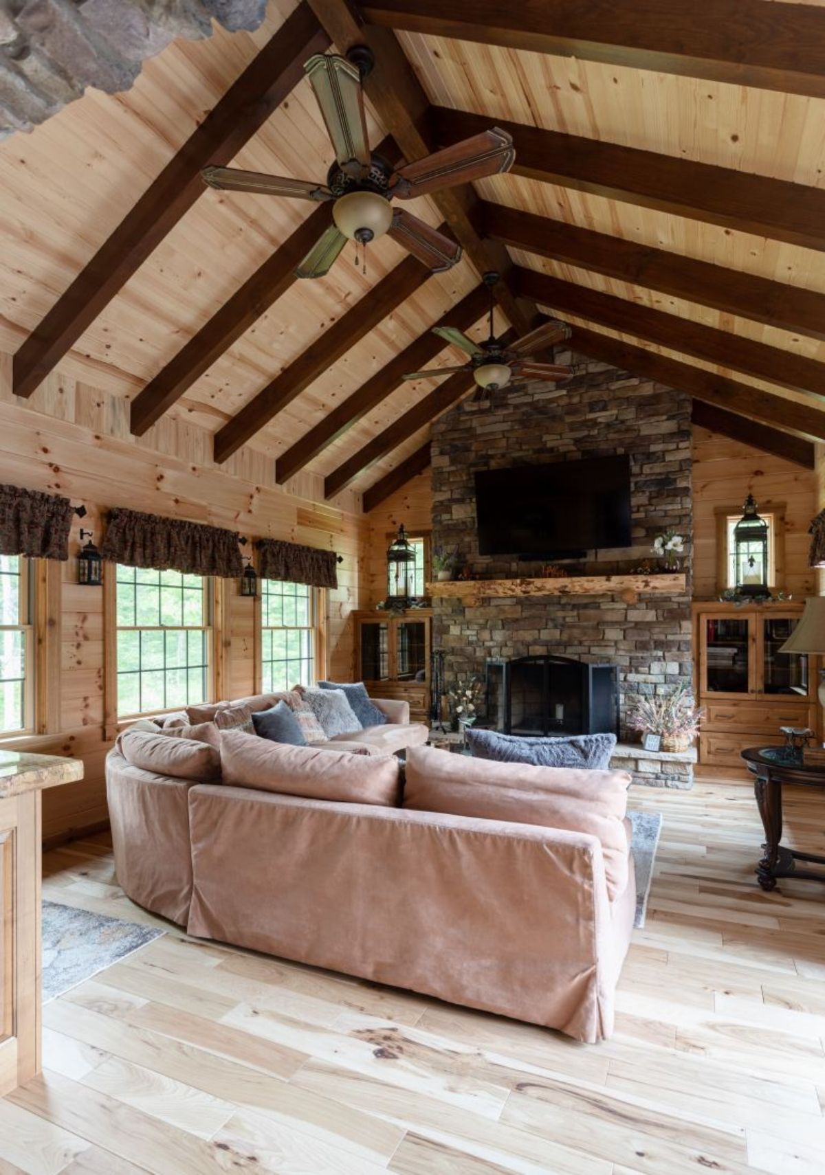 ivory sofa inside log cabin living room with dark wood exposed beams in ceiling