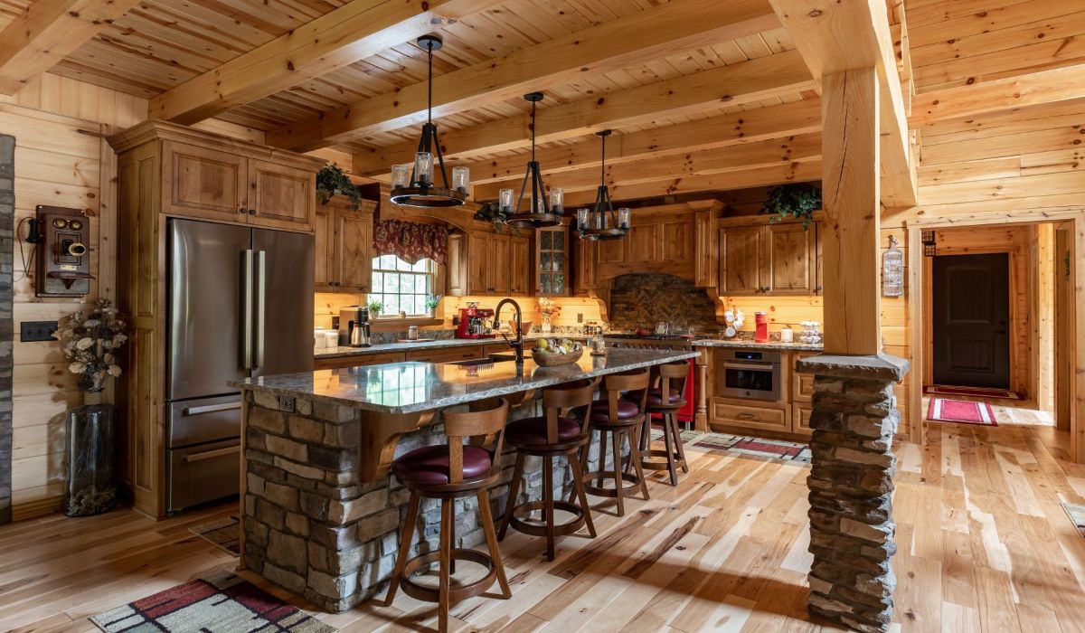stone surrounding isalnd in kitchen with wood stools underneath danglling lights