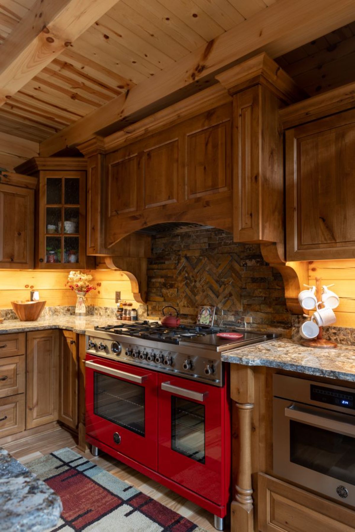 red gas stove in kitchen with rustic wood backsplash