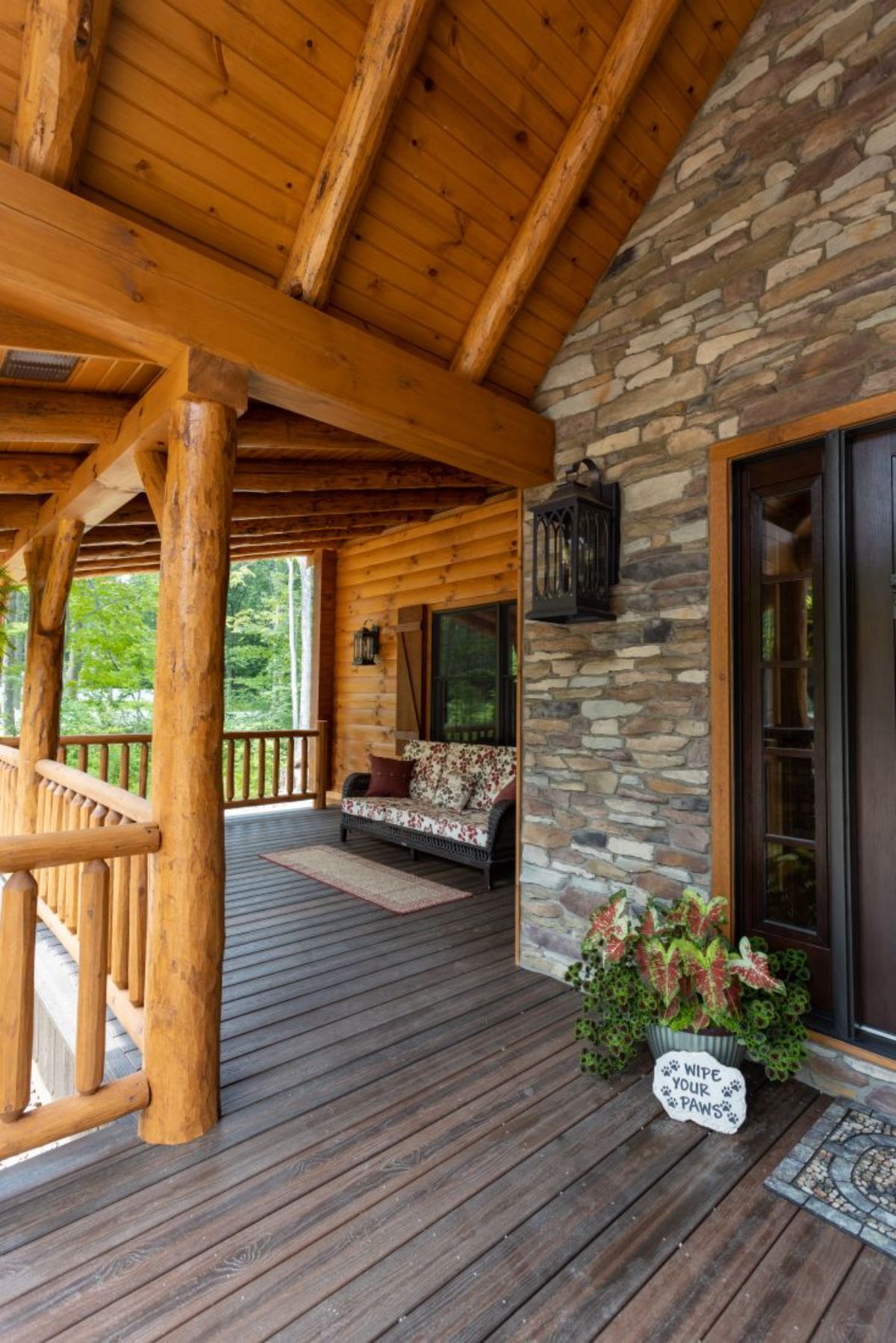 log cabin covered porch with bench seat under window to left of image