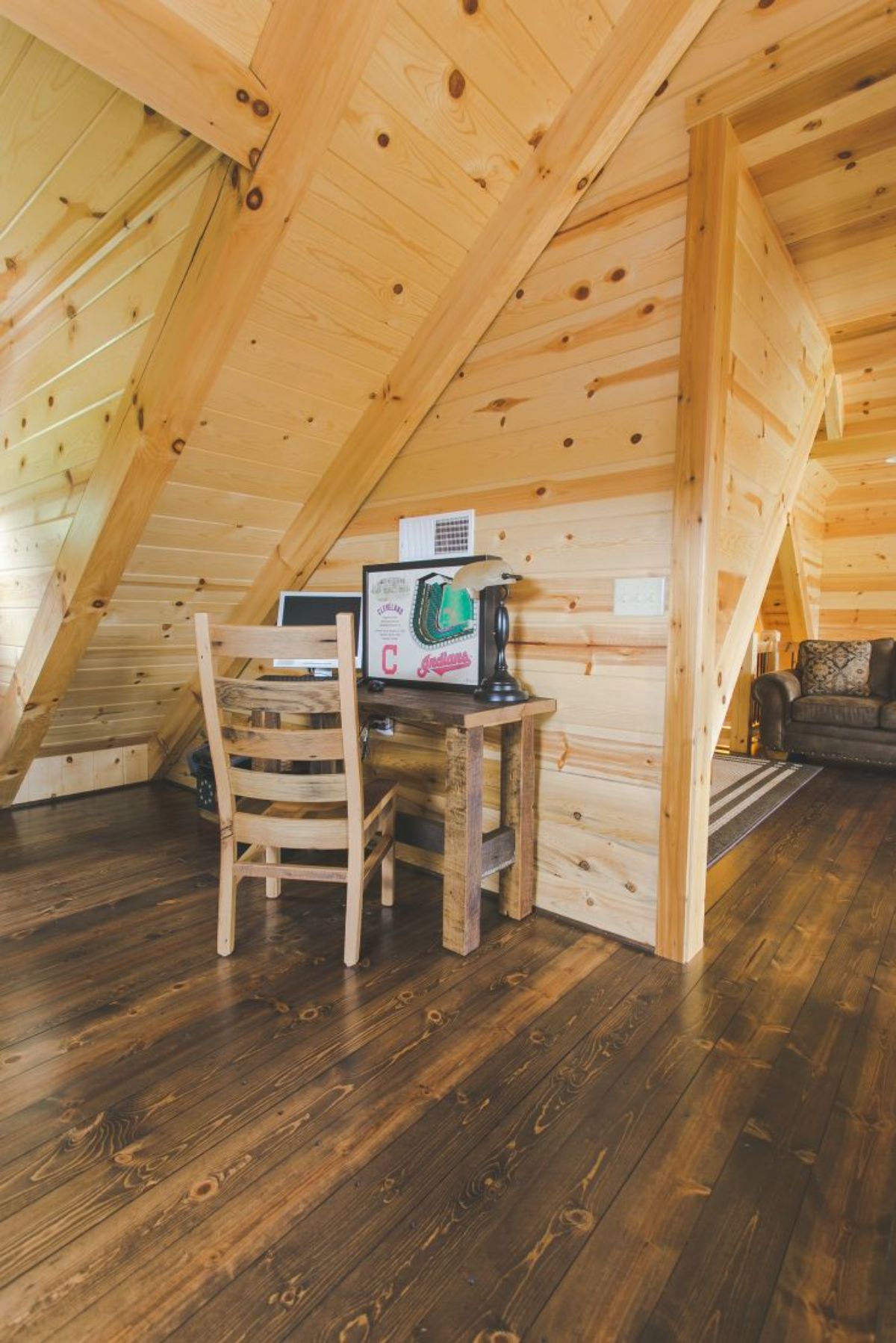 small wood table and chair under log cabin eave