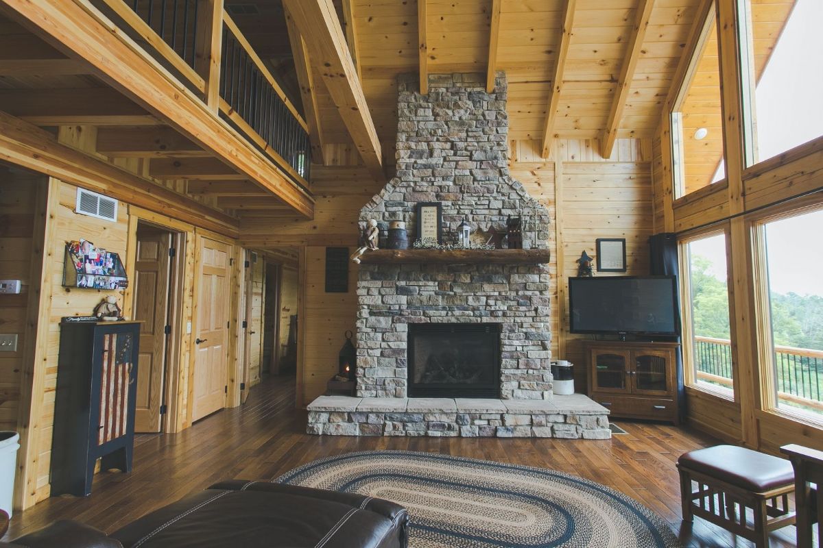 stone fireplace against wall of lo cabin