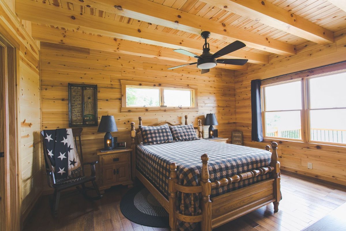 wood bedframe in bedroom with wall of windows