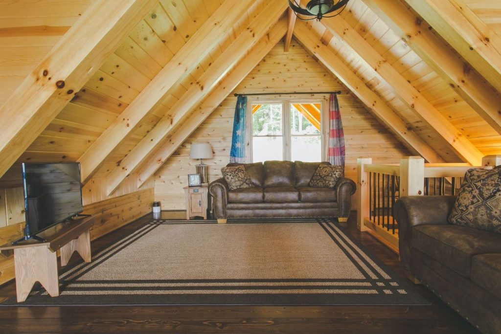 loft family room with brown sofa and cream rug on floor