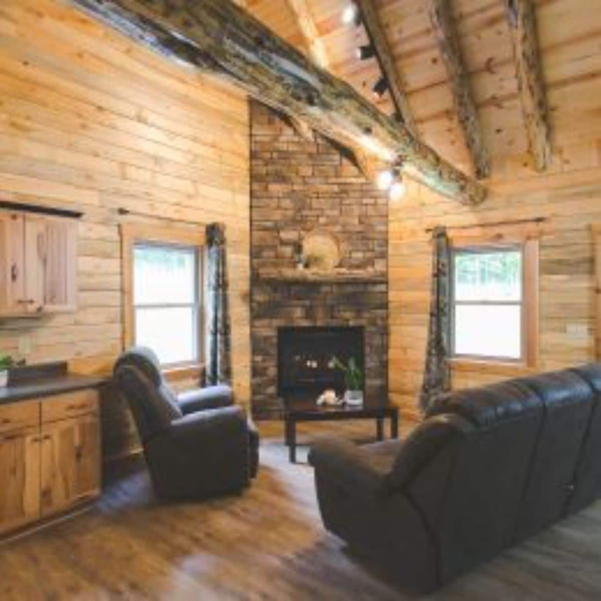 stone fireplace against corner of living area with black sofa