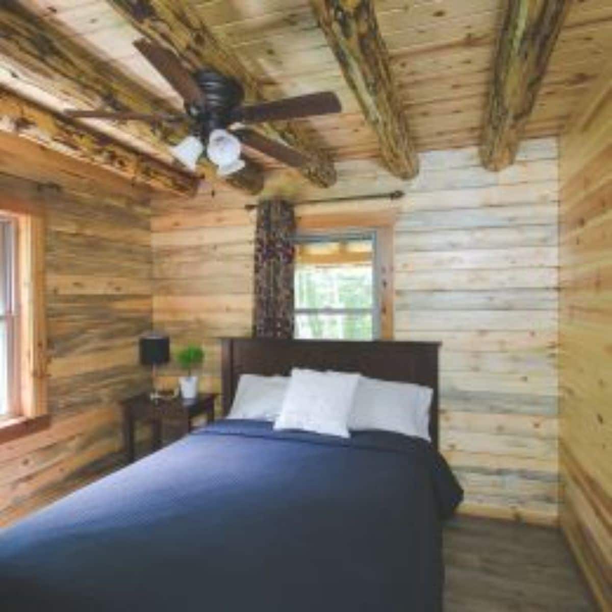 blue bedding on main floor log cabin bedroom