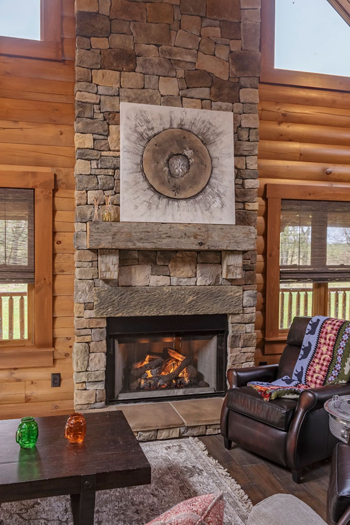 stone fireplace against wall with windows on both sides