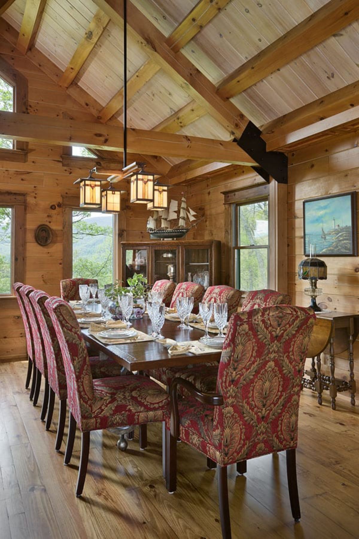 cloth covered chairs around formal dining room under dangling light fixture