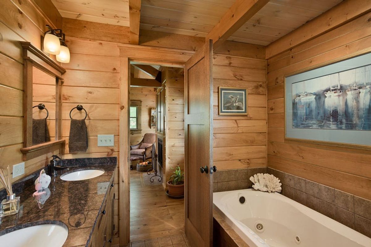 soaking tub on right of bathroom with two person vanity with wood top on left