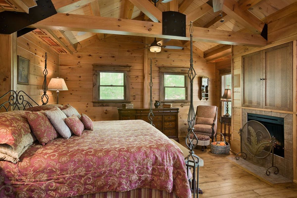 loft bedroom with rocking chair in corner and light pink bedding on bed on left of room