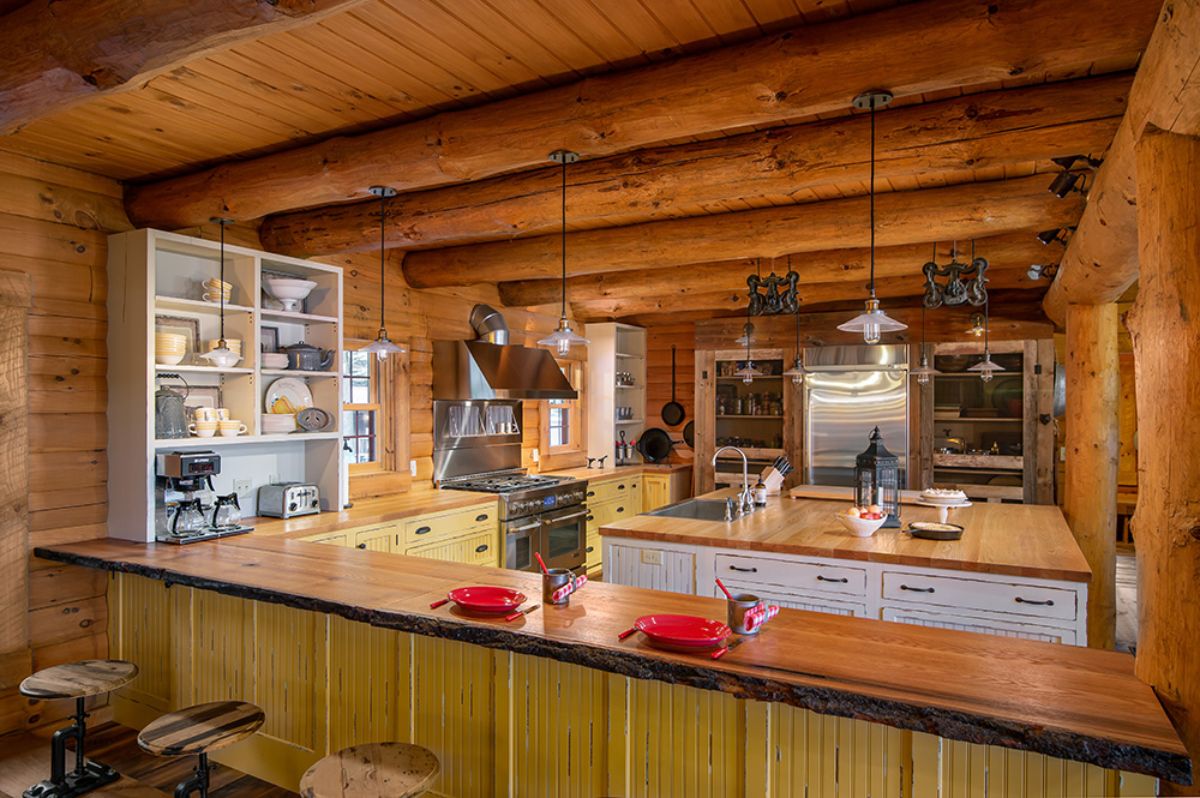 light green cabinets underneath wood counters in log cabin kitchen