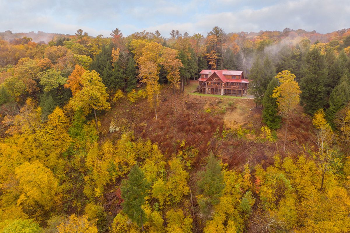 log cabin on hill with trees around it