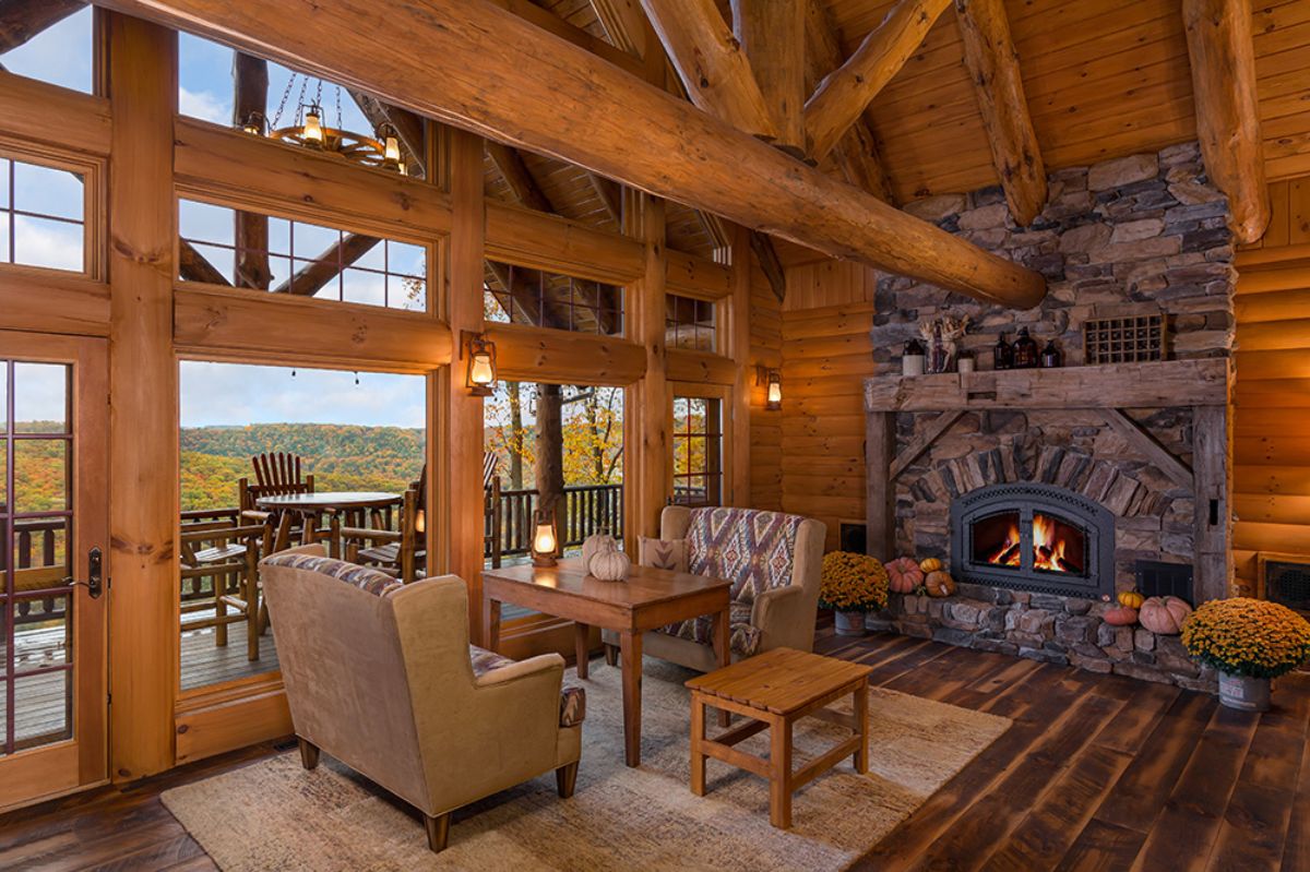 light brown chair by wood tables with fireplace on right corner of image