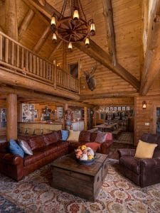 brown leather sofa with wood coffee table under log cabin rafters