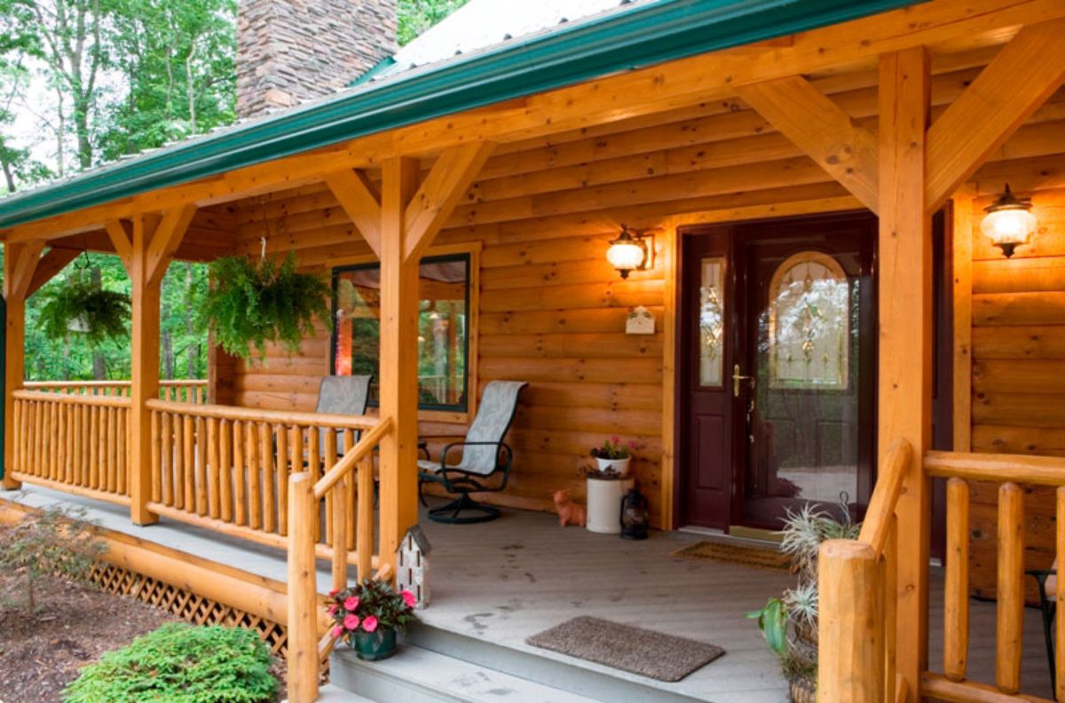 front porch with wood door and milk jug on left of door and log roofline