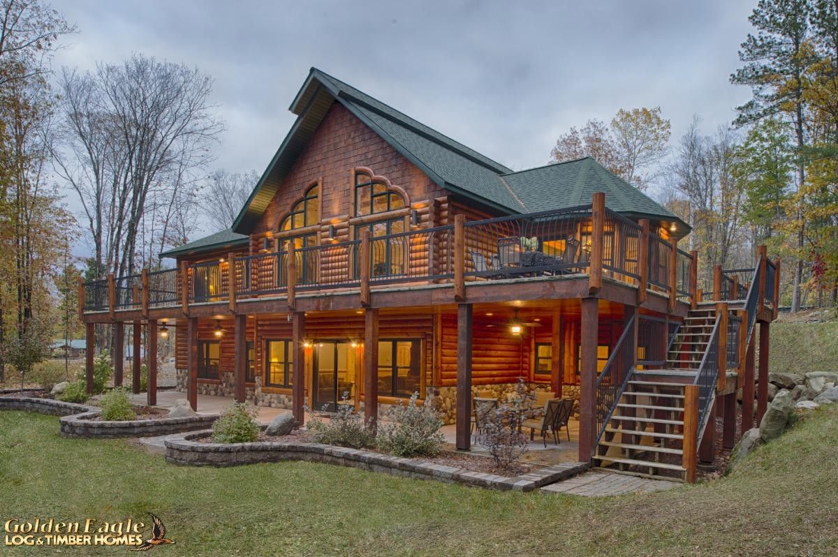 back of log cabin with deck on top level and covered walkout bottom floor