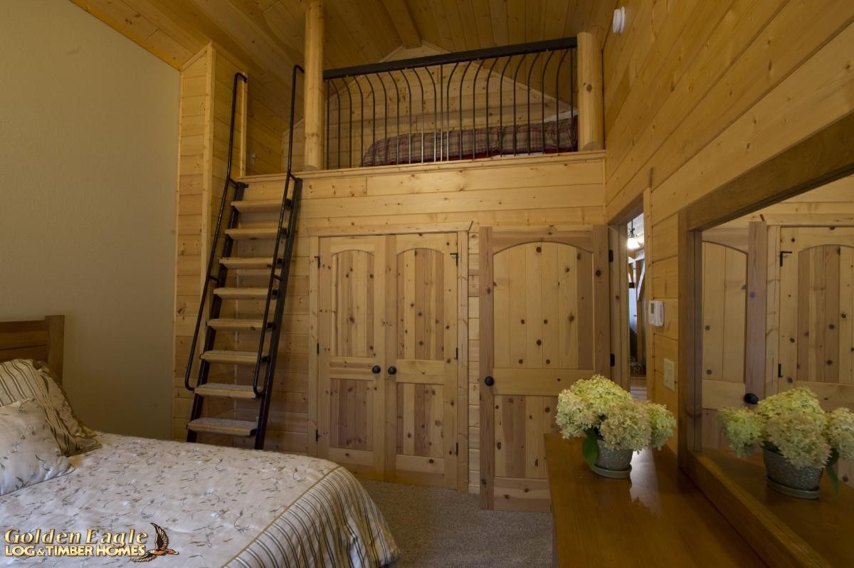 wood doors at back of image with black and wood ladder leading to loft with black railing above doors